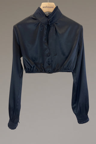 schwarze seidendirndlbluse mit breitem stehkragen mit rueschenabschluss, gezuegelter langarm mit manschette und rueschenabschluss, ueberzogene knoepfe, um den stehkragen zu schließen, ausschnittschlitzchen vorne, leiste mit ueberzogenen knoepfe und leicht gezuegelt am halsausschnitt, anliegend an aermel und oberkoerper, gummizug an taille für den perfekten halt, ideale passform, wallmann